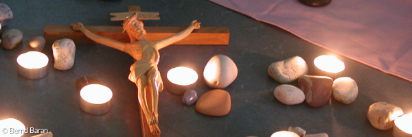 Kreuz mit Teelichtern und Steinen